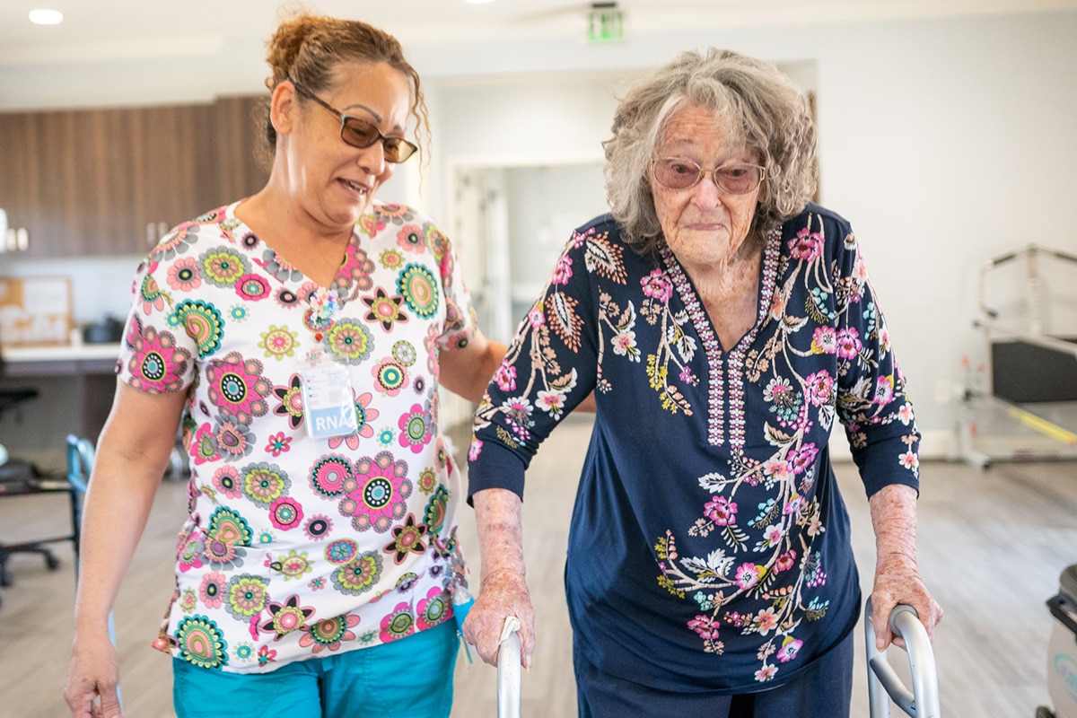 Therapist helping senior with walking